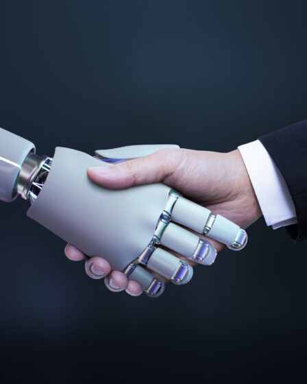 robot i człowiek ściskający dłonie