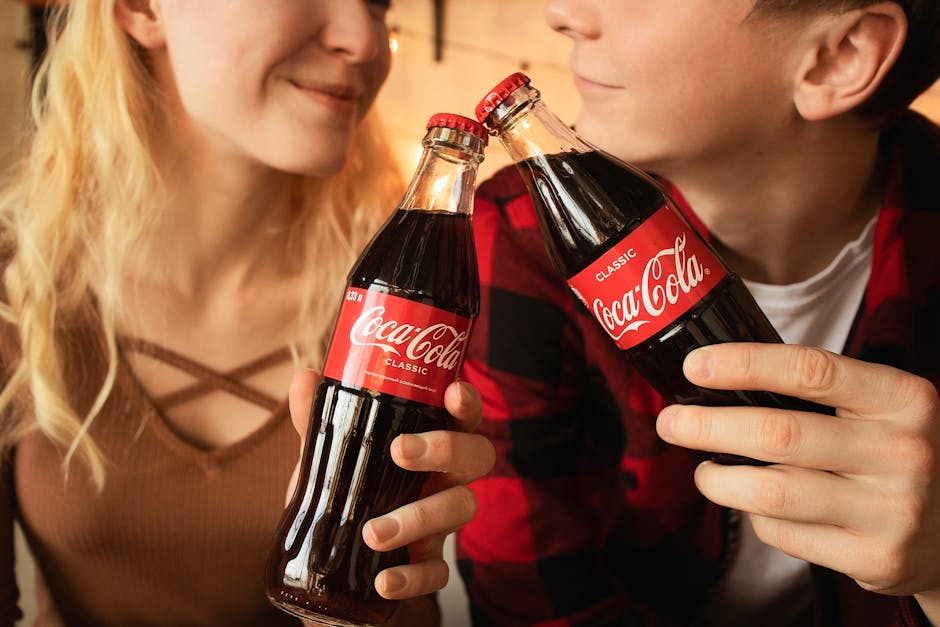 kobieta i mężczyzna stukający się butelkami coca-coli
