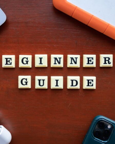 Białe klocki z literami układają się w napis Beginners Guide na drewnianym stole.