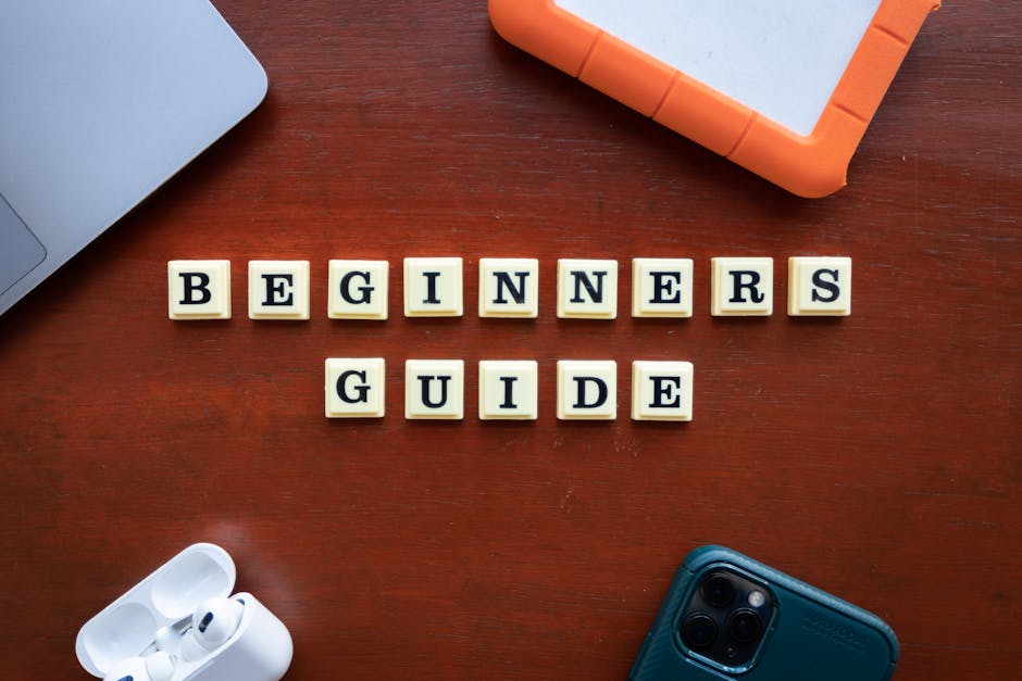 Białe klocki z literami układają się w napis Beginners Guide na drewnianym stole.