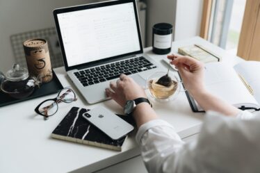 kobieta parząca herbatę przed laptopem