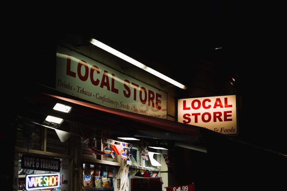 Szyldy sklepu spożywczego z napisem „Local Store” nocą na ulicy miasta.