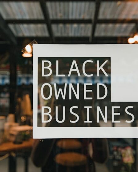 Naklejka z napisem „Black Owned Business” na szybie witryny sklepowej.
