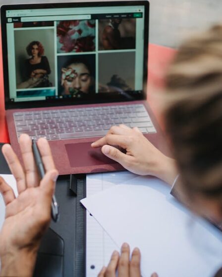 dwie osoby pochylone nad laptopem i notatkami